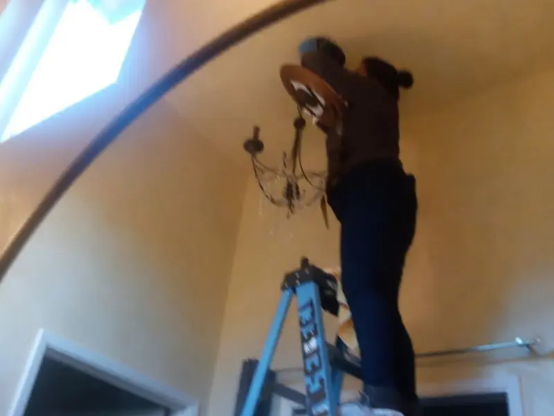 Electrician installing a chandelier in a Hyattsville residence